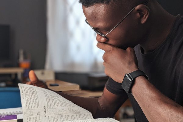 man-wearing-black-crew-neck-shirt-reading-book-3118214